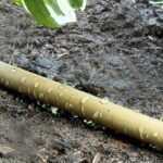 The soaker garden hose watering plants evenly with its porous structure for optimal moisture.